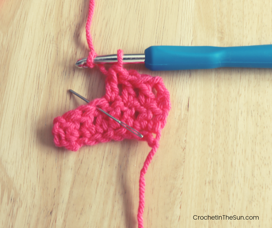 Step 2 of completing the Double crochet stitch: Yarn over your hook from back to front.