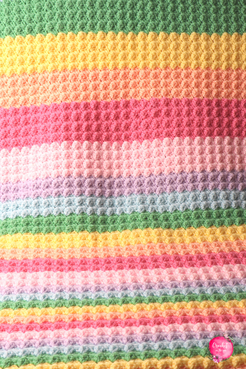 Rainbow crochet blanket pattern that's free, easy, quick to work up, and beginner friendly. This includes a photo tutorial. Make your own crocheted rainbow blanket!!