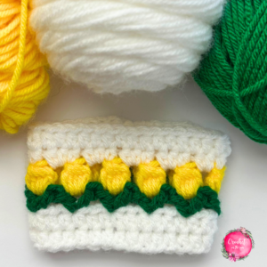 Free crochet pattern - Tulip Cup Cozy. See the blog for the FREE pattern and photo tutorial. This is a beginner-friendly 30 minute crochet project. #crochet #crochettutorial #crochetinthesun